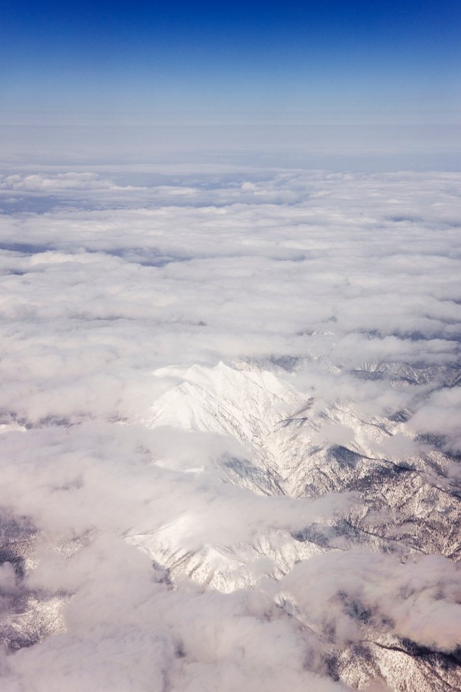 Aerial view shows snow-covered mountain peaks, Hokkaido, Japan.