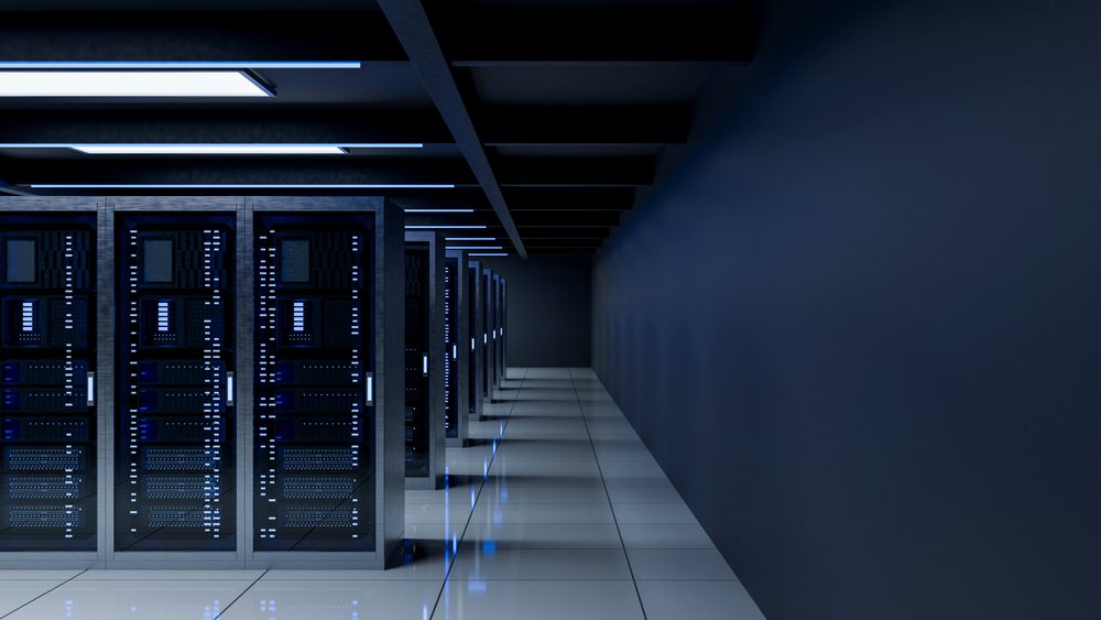 Data center corridor featuring illuminated server racks and advanced digital technology equipment in a modern technology room.