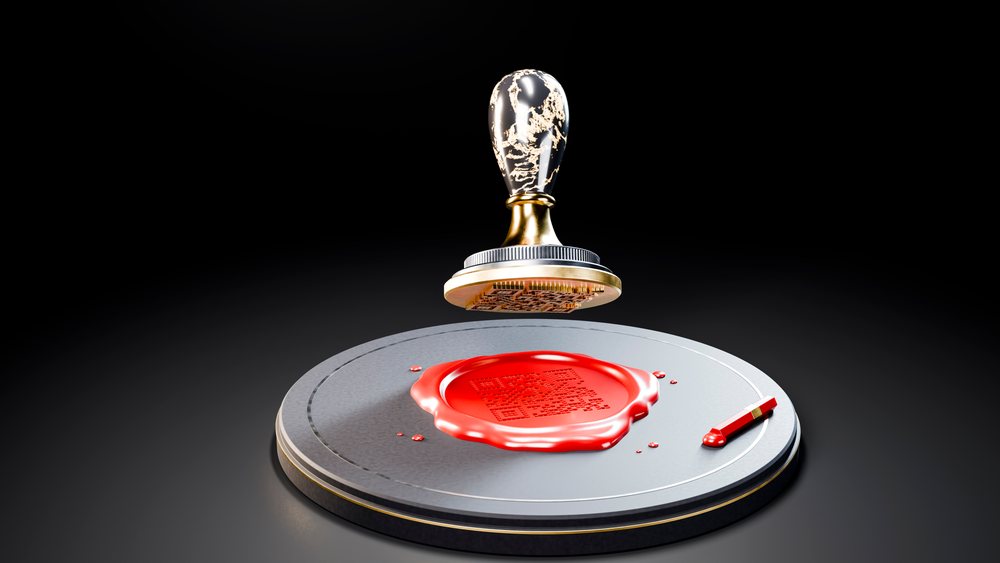 Wax seal press with a detailed engraved stamp is held above a red wax seal embossed on a round metal base against a black background.