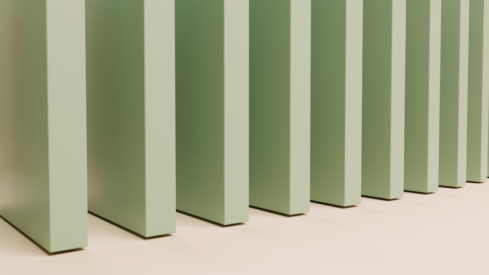 Green vertical bars aligned in parallel on a neutral surface create a minimalist geometric pattern with soft shadows.