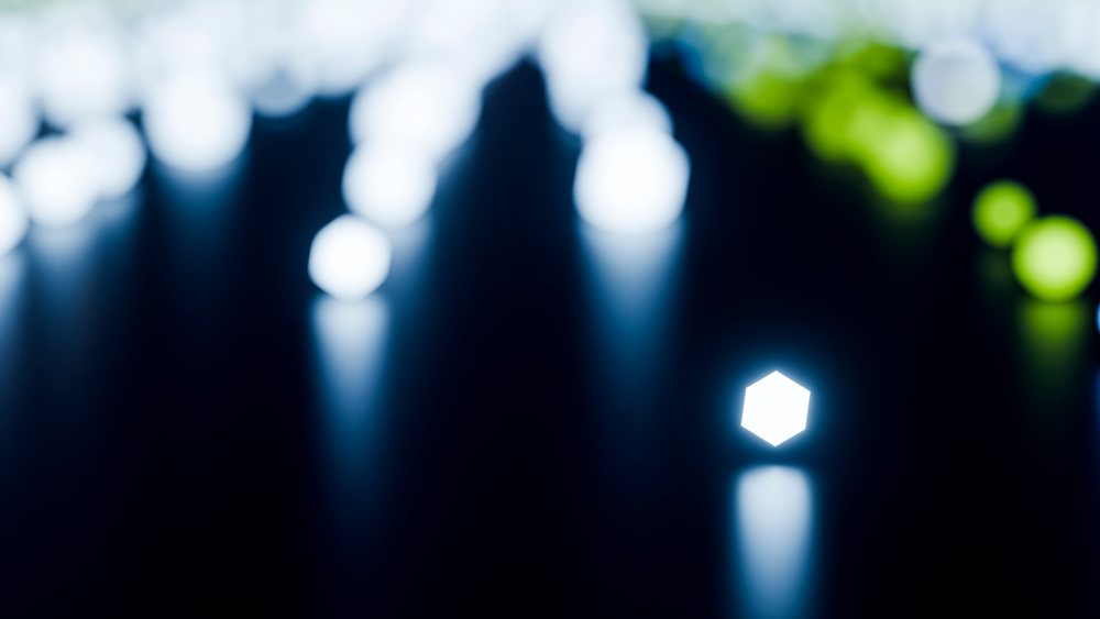 Glowing hexagon-shaped lights reflect on a dark surface with blurred blue, white, and green bokeh effects.