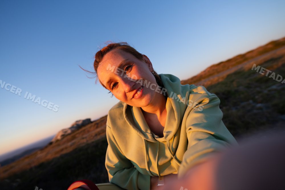 A young white woman taking a selfie outdoors