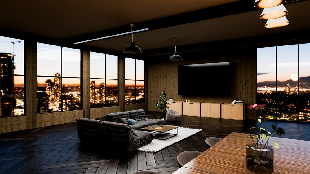 Modern living room interior with large floor-to-ceiling windows showing a cityscape at sunset.