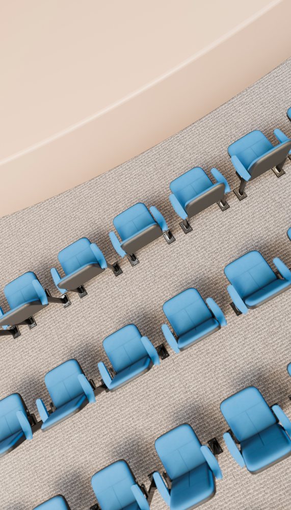 Blue chairs with armrests arranged in multiple rows on carpeted floor in a conference room with light beige walls.