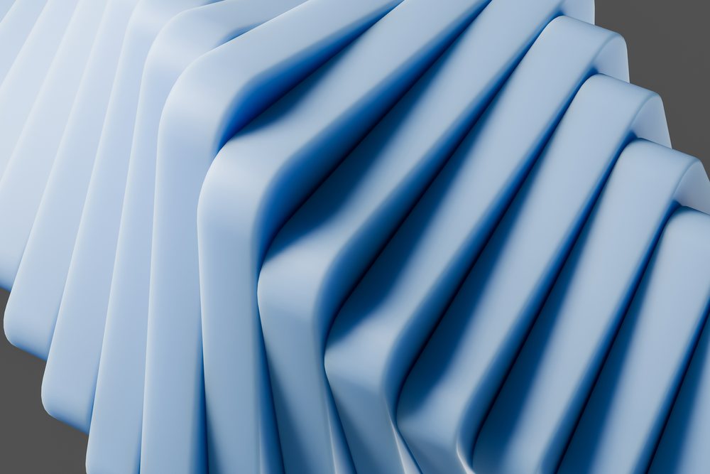 abstract render of smooth blue folded shapes with curved surfaces and undulating design.