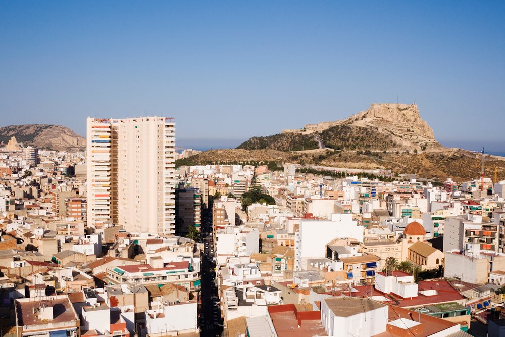 Castle of Santa Barbara on a hill overlooking Alicante cityscape under a clear blue sky along the Mediterranean coast, Valencia, Spain.