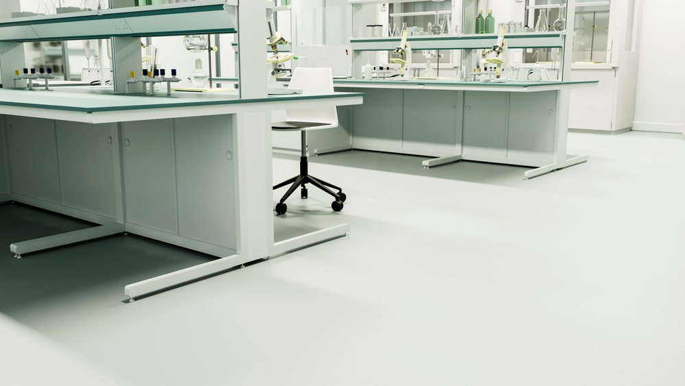 Bright laboratory workspace featuring microscopes, glassware, and a white chair arranged on clean lab tables.