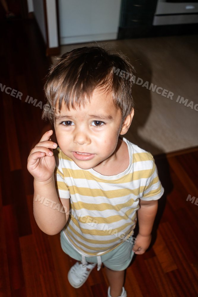 Young toddler white boy standing indoors on wooden floor