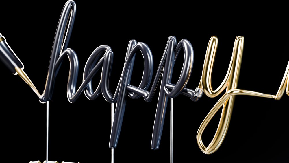 Inflated black and gold letter balloons form the word happy against a black background.