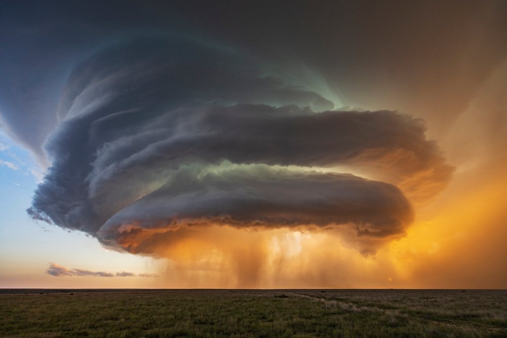 Rotating Supercell storm cloud with rain is seen at Sunset over grassy plains, Amistad, New Mexico, USA.