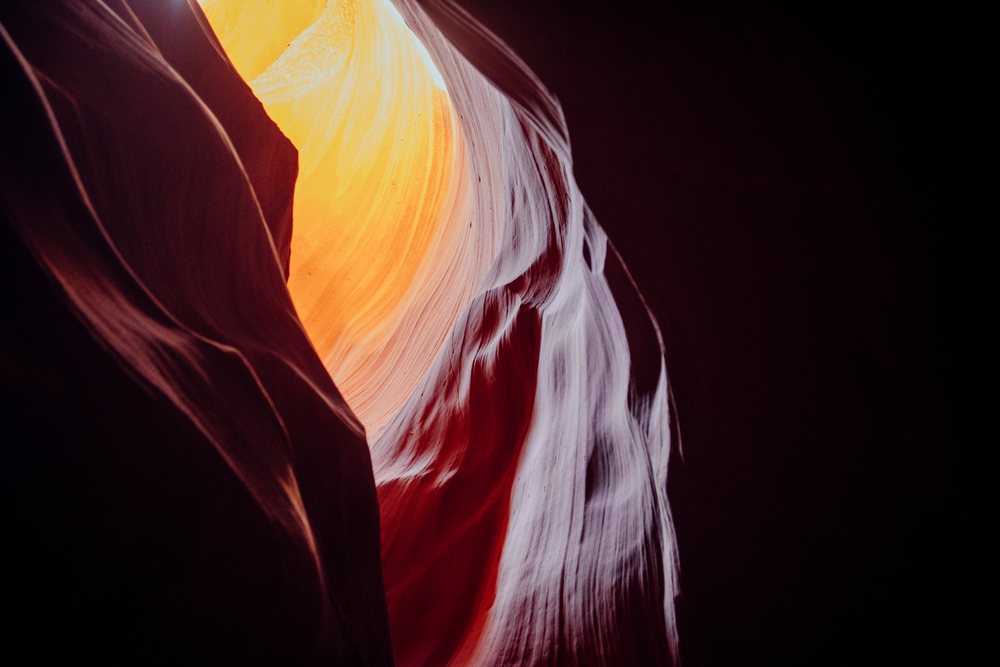 Natural light illuminates textured sandstone walls inside slot canyon, Navajo Land, Arizona, USA.