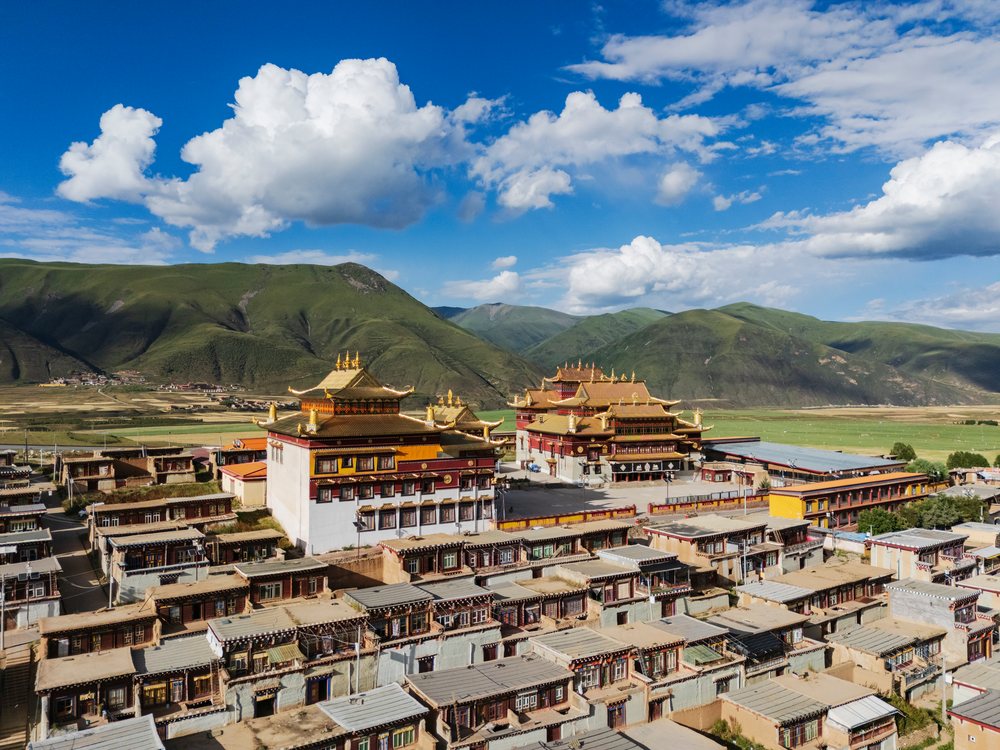 Dajin Temple and adjacent monks residences are set in Kagongxiang village amid green mountains under a blue sky, China, Sichuan Province, People's Republic of China.