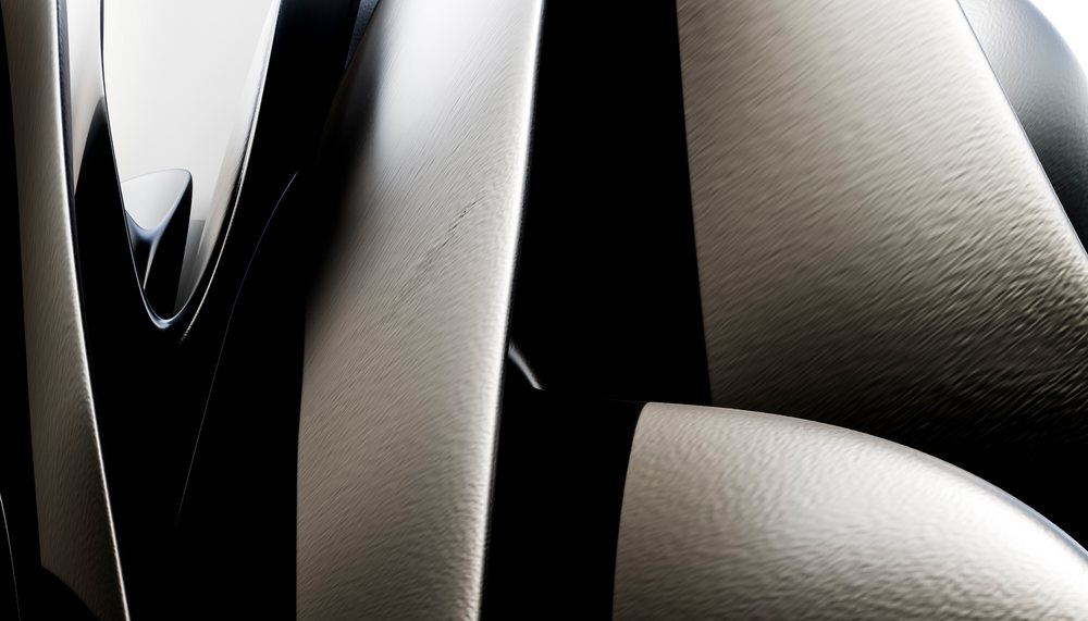 Close-up view of a modern abstract metallic sculpture with smooth curved surfaces and reflective textures.