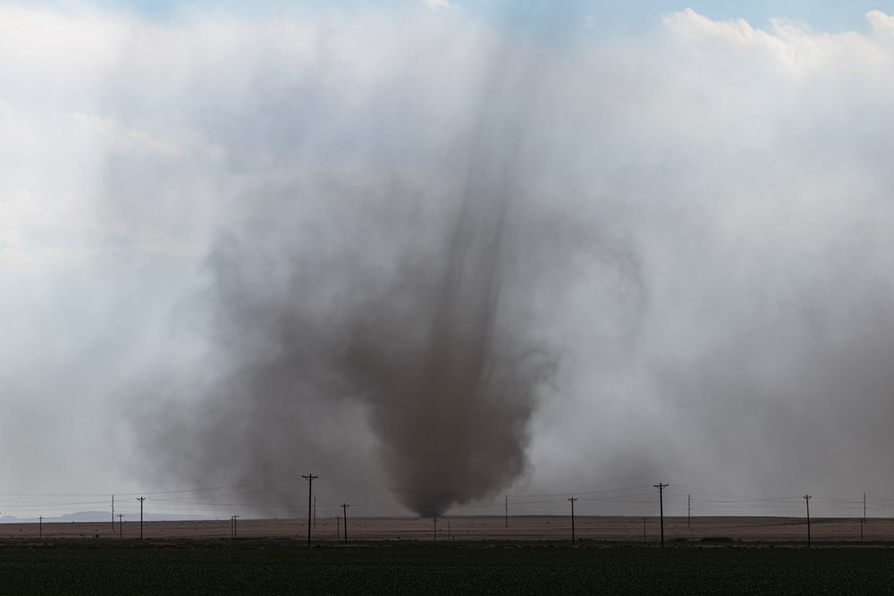 Landspout tornado with a narrow rope-like condensation funnel over a rural plain near County Road 2, Storm Chasing, Weather, Environment, Fowler, Colorado, USA.