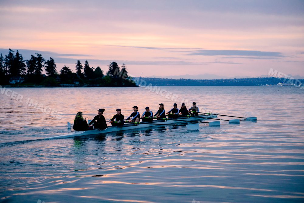 Rowing team practicing on the water at sunset in WA, USA