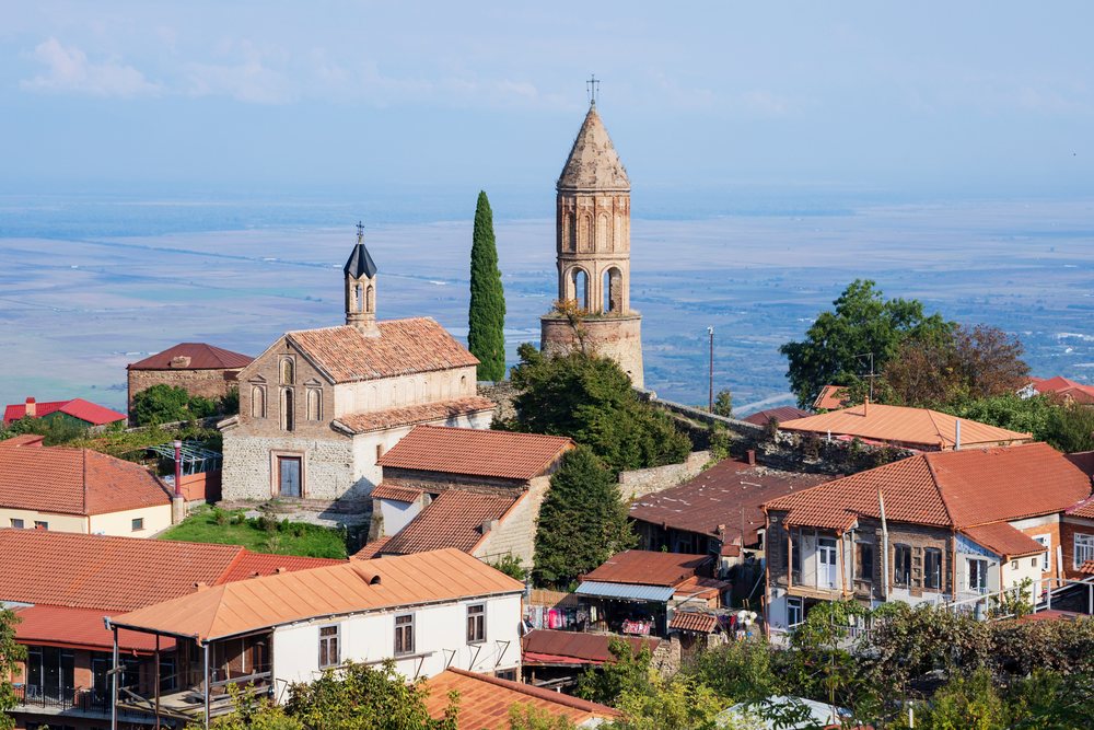 St George Basilica and bell tower in Sighnaghi town overlook a panoramic Georgian landscape with mountains and houses, Skylines, Sighnhagi, Georgia.