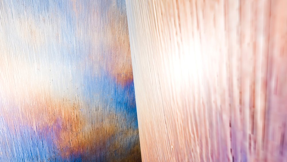 Close-up of colorful textured wood panels showing natural grain patterns and vibrant tones.