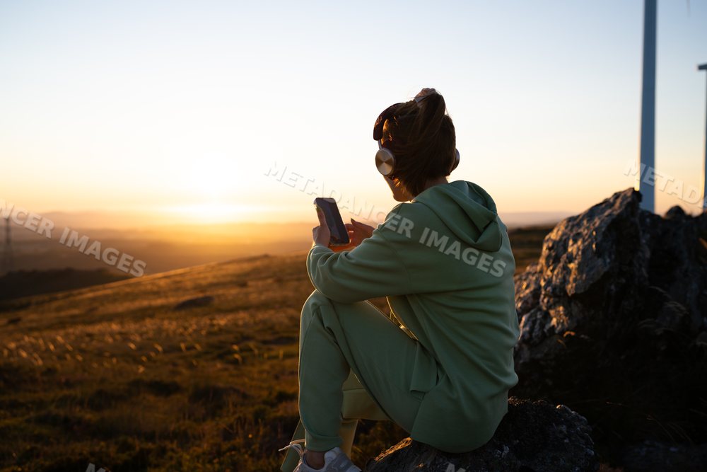 White Woman with headphones using smartphone outdoors