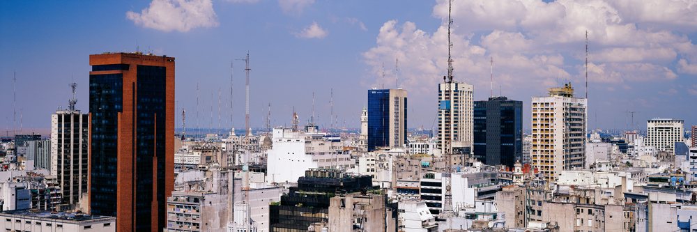 Skyline of Buenos Aires showing high-rise buildings and antenna towers under a partly cloudy blue sky in a dense urban area, Skyline Buenos Aires, Argentina.