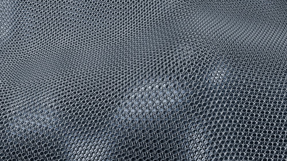 Close-up of interlinked metal rings forming a chainmail armor pattern showing detailed craftsmanship.