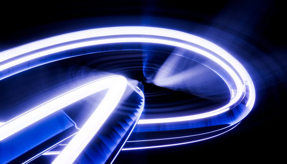 Spiral structure glowing with blue light trails on a dark background.