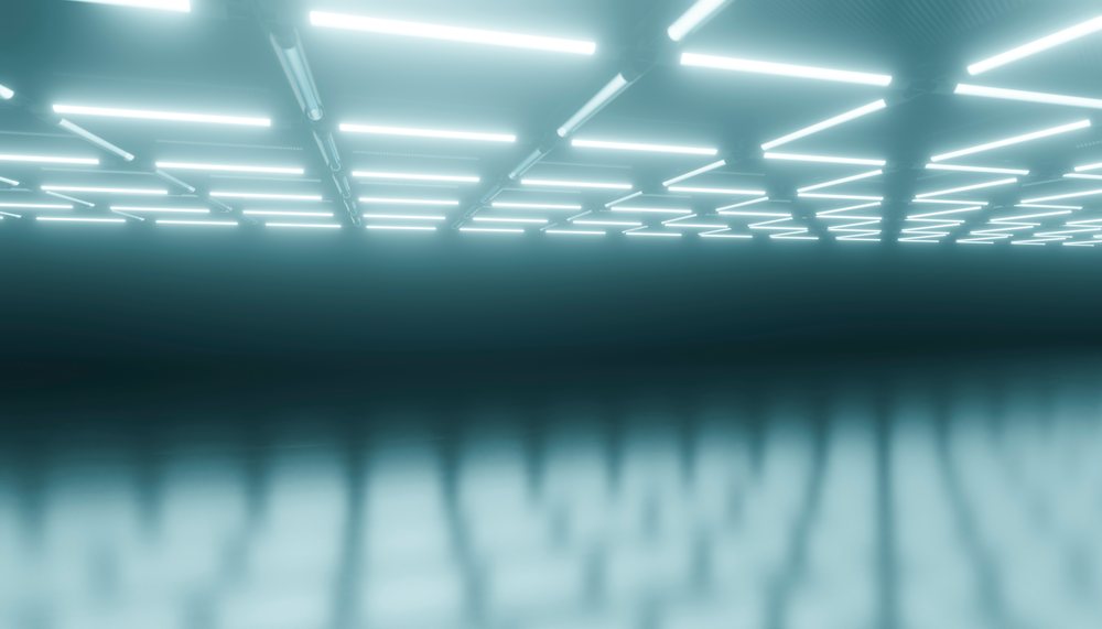 Interior of a data center with rows of fluorescent lights reflecting on the shiny floor.