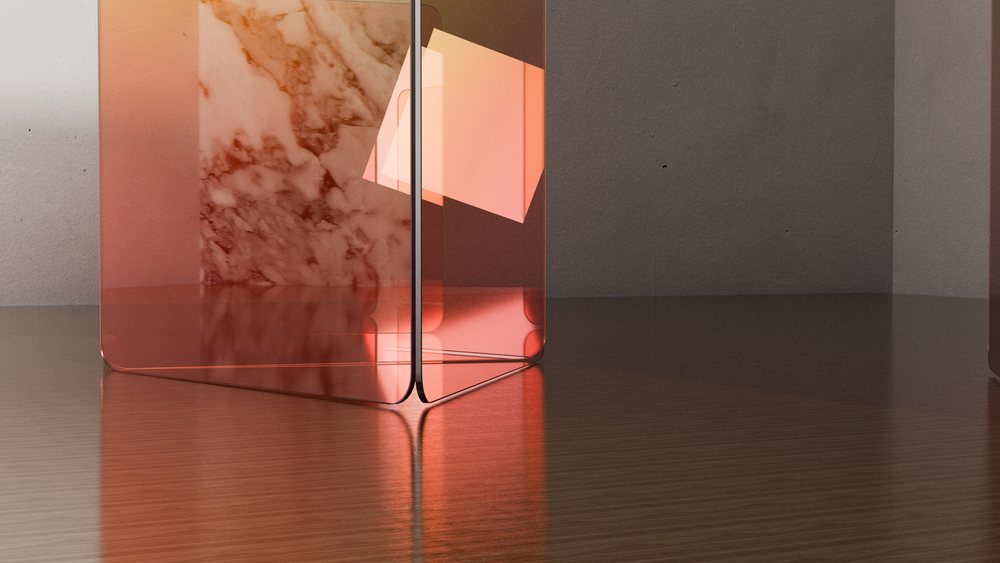 Transparent orange glass cube with a marble wall background reflecting softly on a wooden surface in a studio setting.