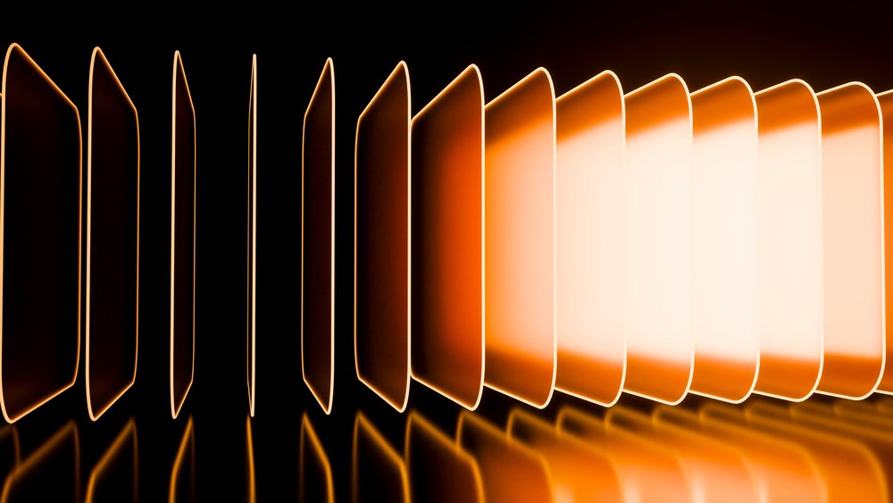 Glowing abstract orange panels arranged decoratively in a row with reflections on a black surface in a modern artistic setting.