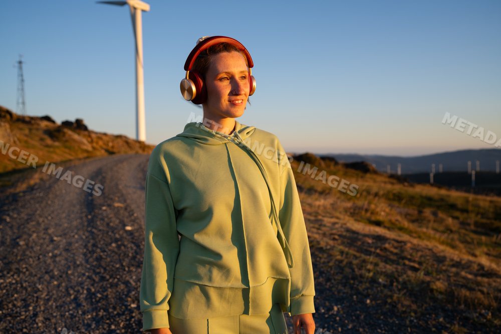 White Woman wearing headphones walking