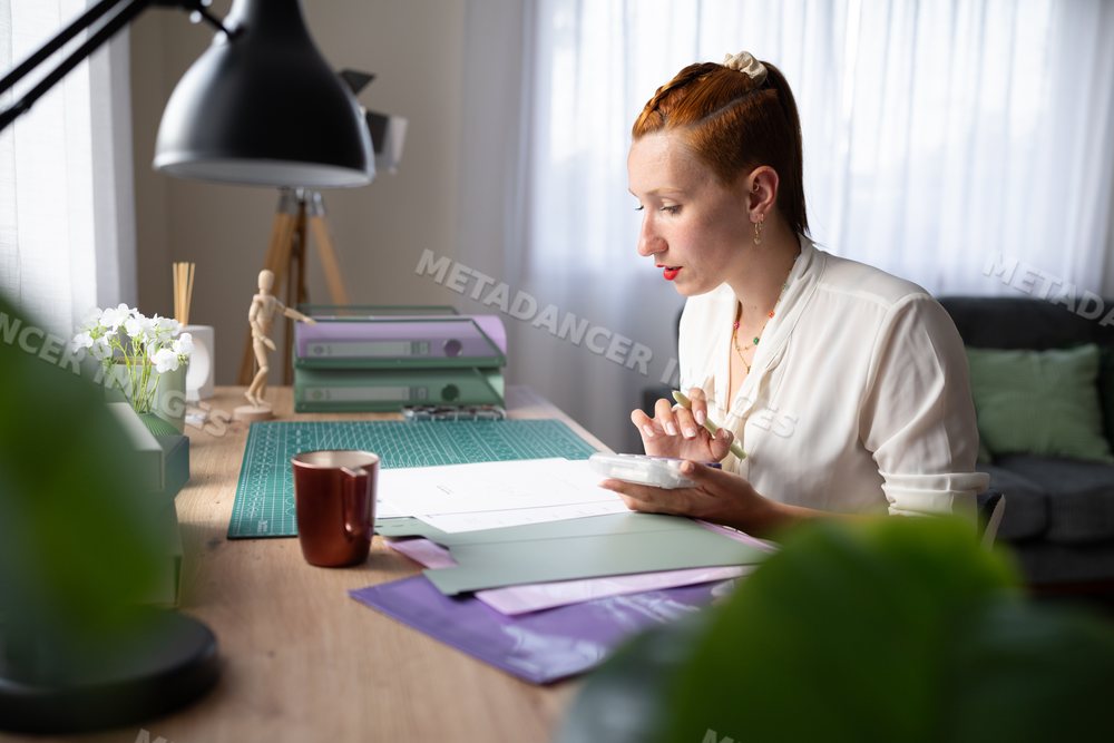A white woman working at her desk in a bright home office in Galicia