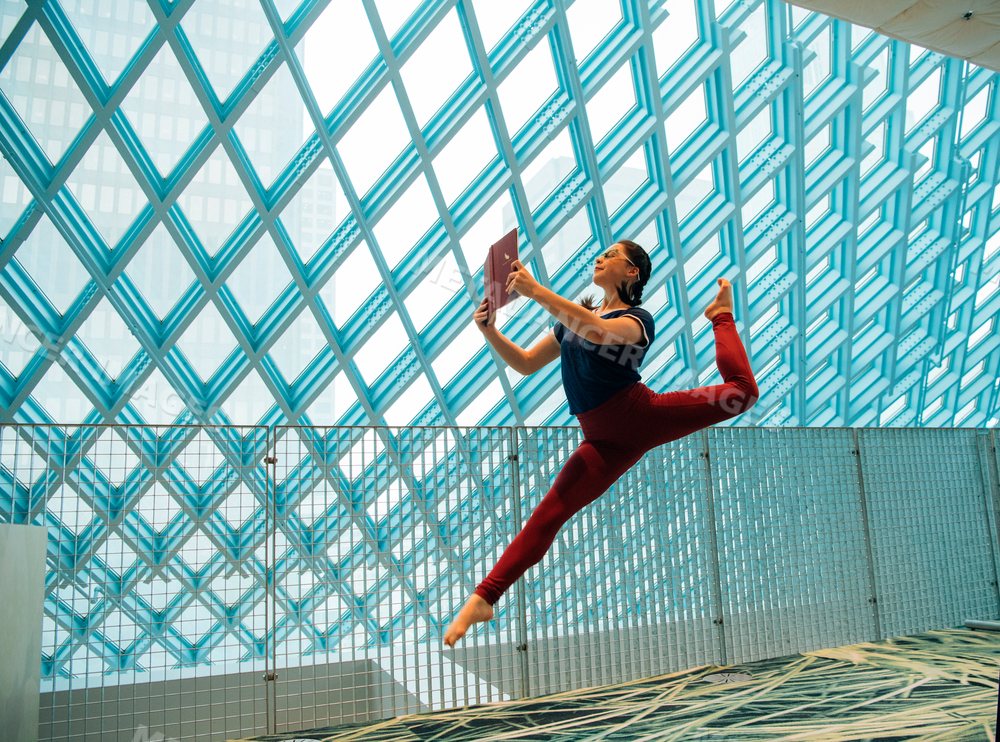 A woman jumps while reading a book inside the Seattle public library