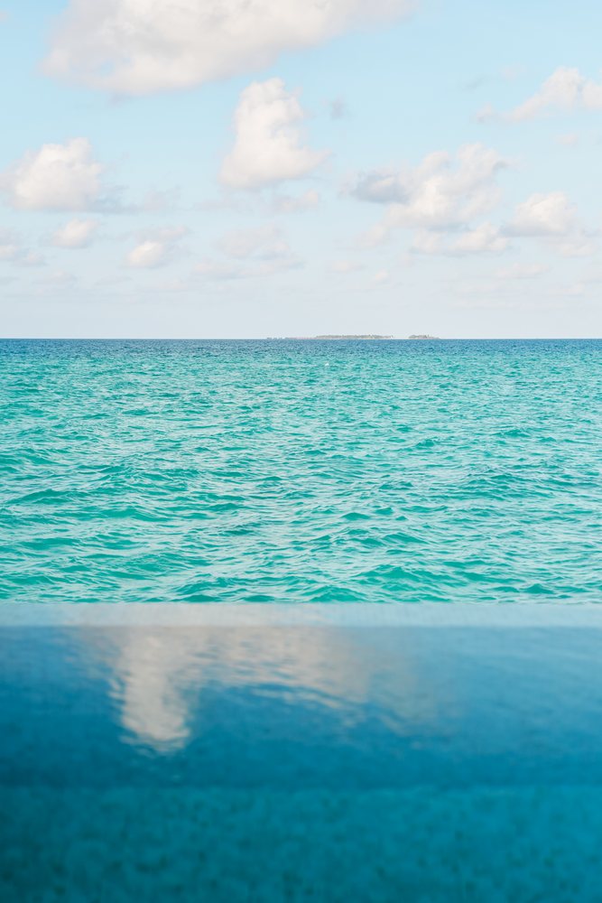 A turquoise sea and infinity pool with distant islands