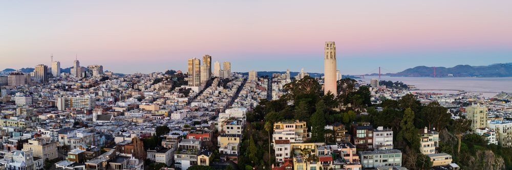 Telegraph Hill with Coit Tower overlooks San Francisco cityscape and Golden Gate Bridge at sunset from Pier 7, landscape, city life, California, USA.