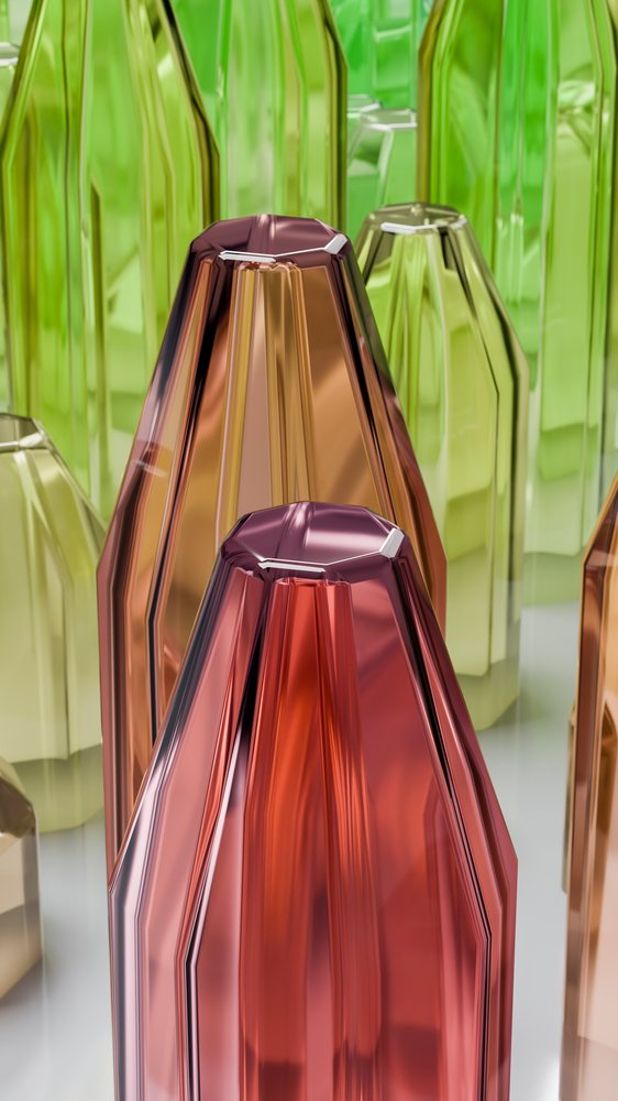 Colored glass bottles in pink, green, and brown tones arranged artistically with reflective surfaces and geometric shapes.