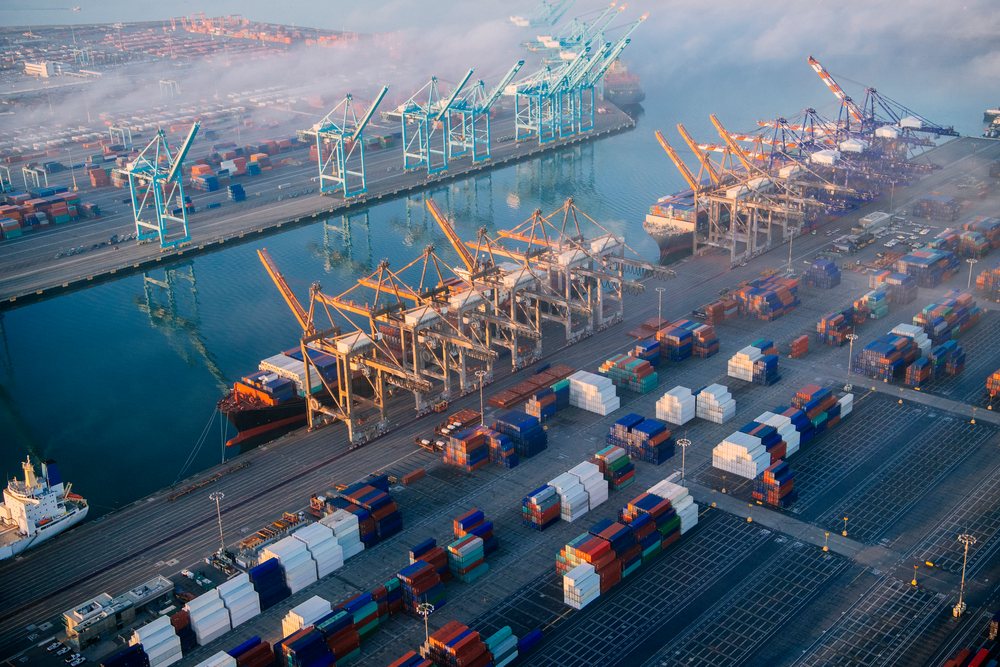 Shipping containers and cargo cranes at a container terminal with a container ship docked at the quay, loted at the, Port of Long Beach, CA, USA.