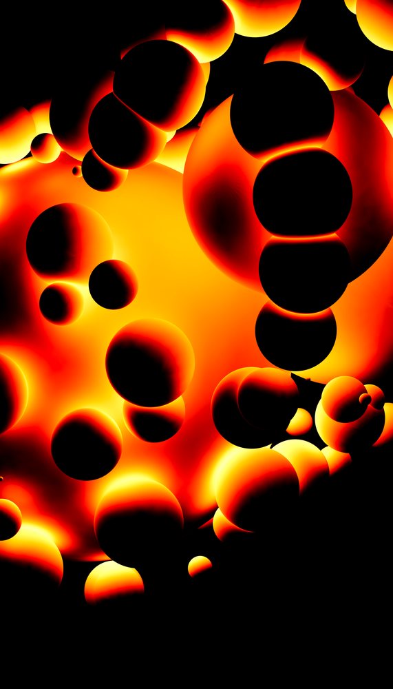 Glowing orange and black spheres float against a black background in this fiery abstract digital art.