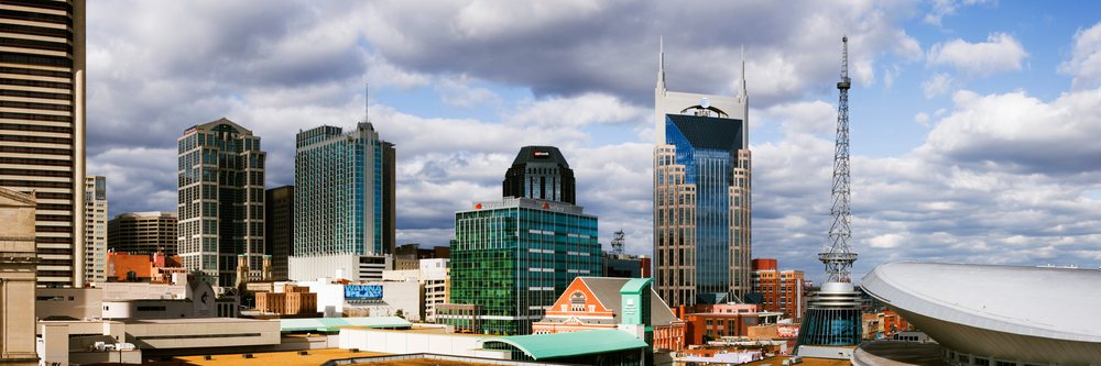 City skyline of Nashville featuring modern skyscrapers and a cloudy sky, Tennessee, USA.