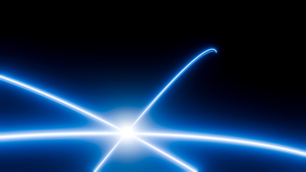 Blue glowing lines curve and intersect smoothly against a dark background, creating an abstract energy effect.