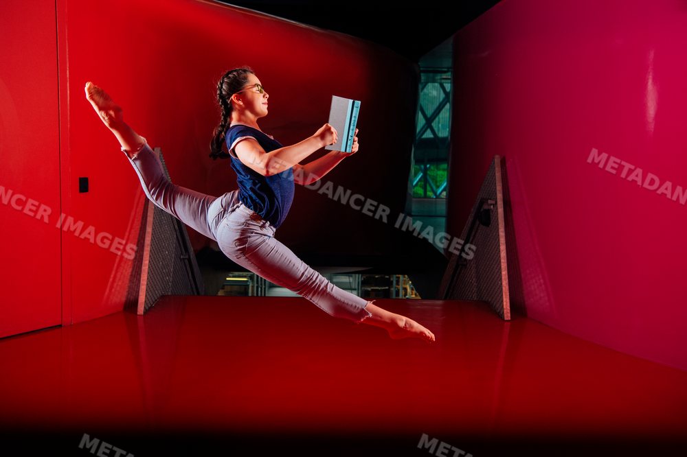 A girl jumps while reading a book inside a Seattle public library