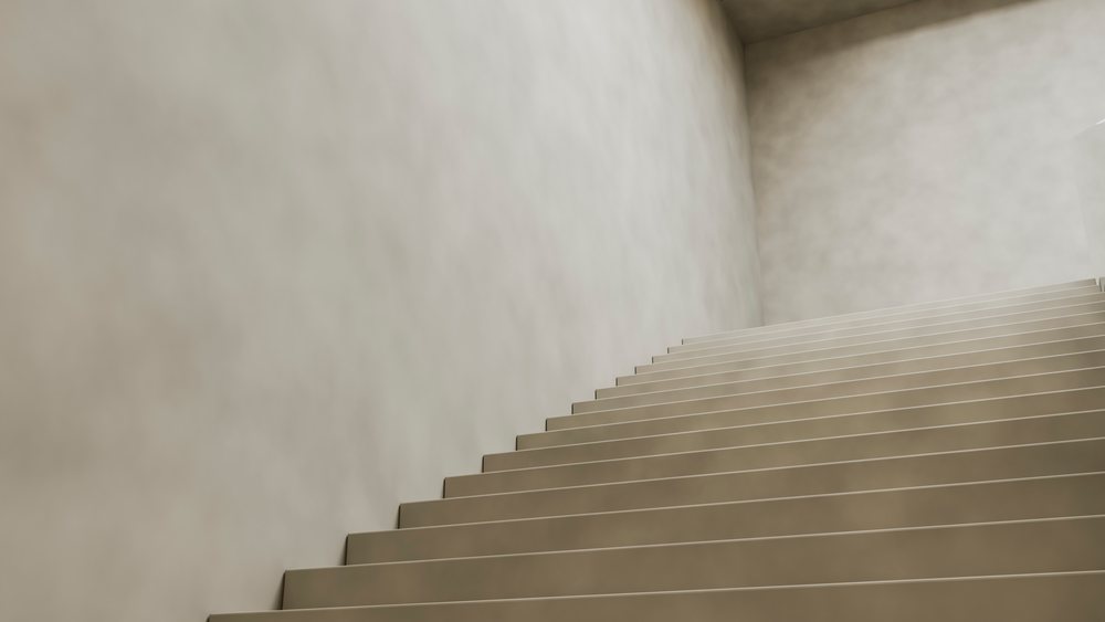 Modern indoor staircase with beige steps and plain walls in a minimalist style interior.