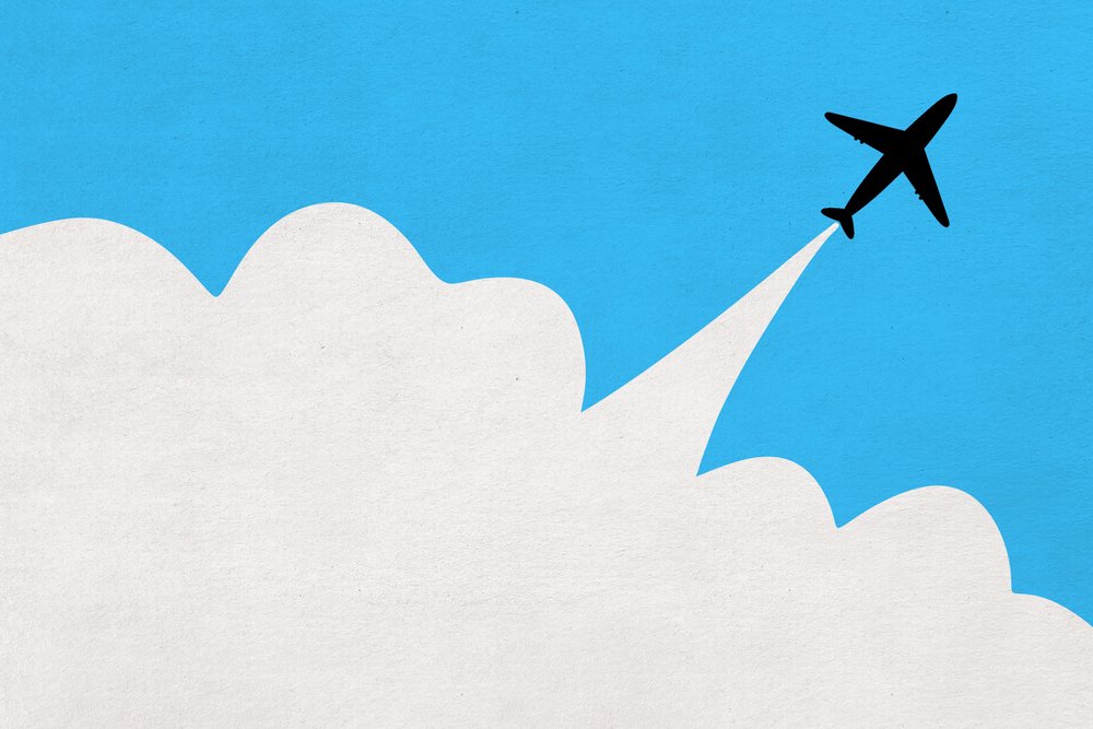 Silhouette of an airplane flying through a blue sky with white clouds and a contrail illustration.
