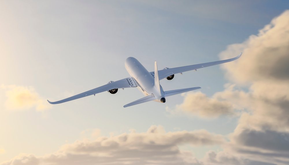 A white airplane flying in the sky at sunset with clouds in the background, travel, fly, vacation.