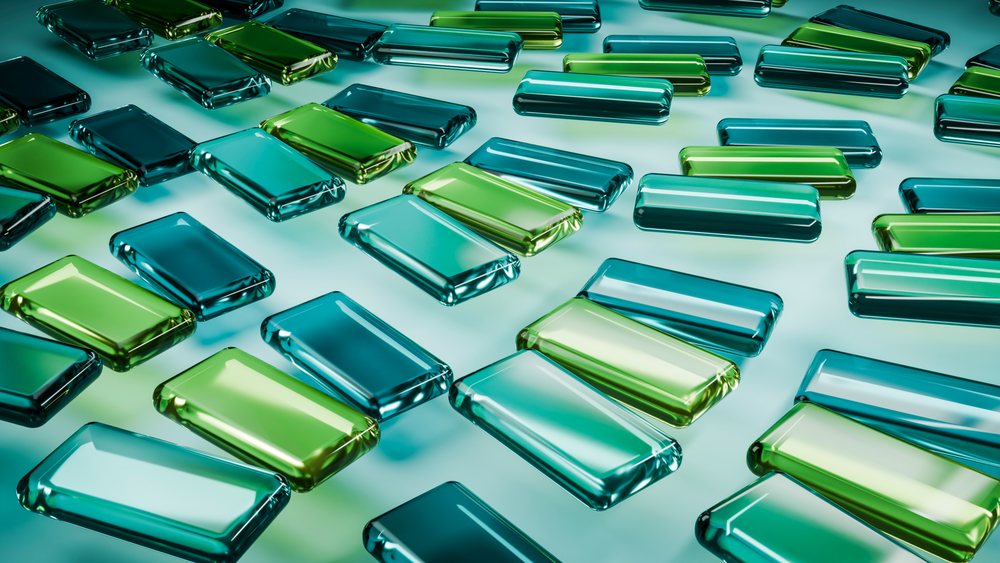 Rectangular green and blue glass tiles arranged in a patterned layout with a shiny reflective surface.