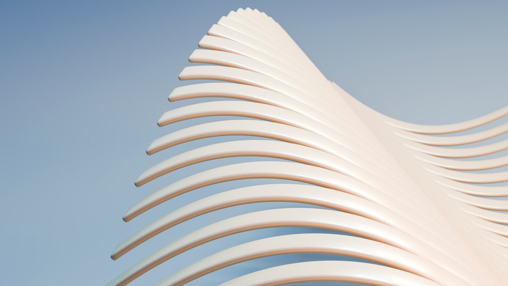 White curved abstract sculpture with smooth flowing lines against a blue background in a minimalist studio setting.