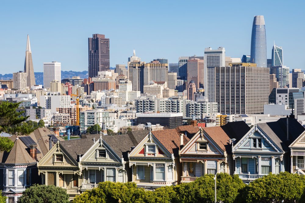 Daytime view of San Francisco's urban skyline with Victorian Painted Ladies on Steiner Street at Alamo Square Park under a clear blue sky, City, Cityscapes, City Life, California, USA.