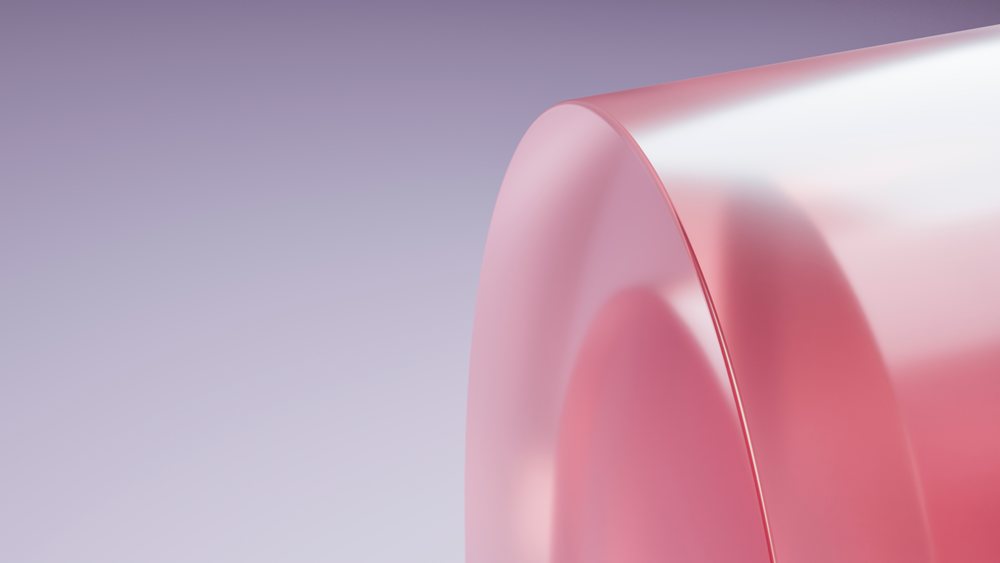 Close-up showing translucent pink gelatin dessert with smooth, shiny, and curved surface texture.