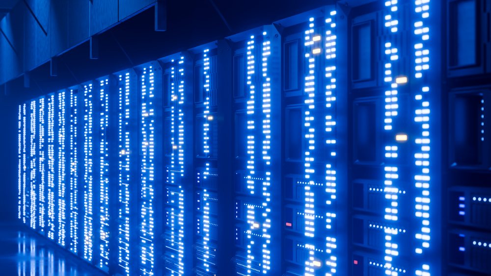 Rows of server racks with blue LED indicators inside a data center room.