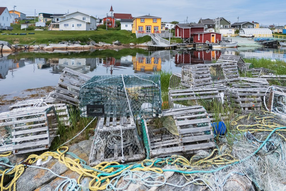 Fishing harbour with lobster traps, nets, and boats docked near colorful buildings, Landscape, Wildlife, Lifestyle, Greenspond, Newfoundland & Labrador, Canada.