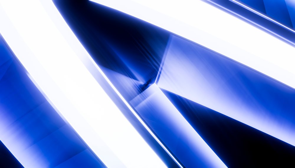 Abstract composition of intersecting blue and white glowing light beams forming geometric shapes with dynamic lighting effects.
