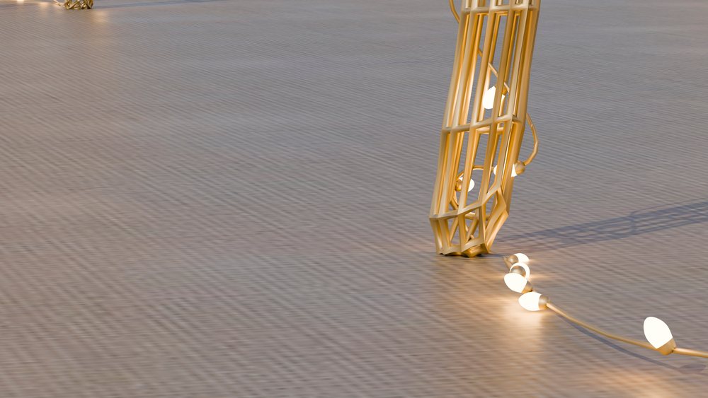 String of glowing bulbs with golden wire cage lampshades on a textured floor surface producing ambient light and shadows.